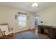 Sunlit bedroom with wooden floor, ceiling fan, and traditional decor at 1269 Rasp Ct, North Port, FL 34288
