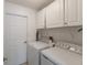 Functional laundry room with white cabinets and modern washer and dryer at 1269 Rasp Ct, North Port, FL 34288