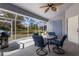 Screened lanai with table, seating, and a view of the green backyard at 1269 Rasp Ct, North Port, FL 34288
