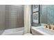 Bathroom featuring tiled shower, stylish wallpaper, and modern marble vanity at 14953 Contenta Loop, Bradenton, FL 34211