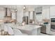 Bright kitchen featuring white cabinets, stainless steel appliances, a tile backsplash, and a large island at 14953 Contenta Loop, Bradenton, FL 34211