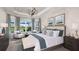 Luxurious bedroom with large windows, water views, neutral decor, and a tray ceiling at 14953 Contenta Loop, Bradenton, FL 34211