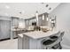 The renovated kitchen features modern lighting and counter seating for entertaining at 1602 Stickney Point Rd # 404, Sarasota, FL 34231