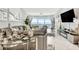 Modern living room with a flat-screen TV, stylish furniture, and lots of natural light at 1602 Stickney Point Rd # 404, Sarasota, FL 34231
