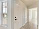 Bright foyer with a white door, light walls, and modern flooring leading to other rooms at 1761 Shevlin St, North Port, FL 34286