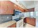 Kitchen boasting granite countertops, wood cabinets, a double sink, and stainless steel appliances at 1761 Shevlin St, North Port, FL 34286