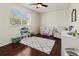 Cozy Bedroom with dark wood floors, a crib, a comfortable armchair, and large window at 1817 91St Nw St, Bradenton, FL 34209