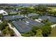 Aerial view of multiple tennis courts surrounded by lush greenery and a picturesque landscape, ideal for active living at 1900 Harbourside Dr # 102, Longboat Key, FL 34228