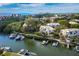 Aerial view of waterfront homes with boat docks, lush landscaping, and ocean view at 1900 Harbourside Dr # 102, Longboat Key, FL 34228