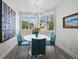 Bright dining nook featuring a round table, modern lighting, and sunlit windows with tropical views at 1900 Harbourside Dr # 102, Longboat Key, FL 34228