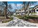 Charming home exterior featuring a scenic pathway through mature trees and well-maintained landscaping at 1900 Harbourside Dr # 102, Longboat Key, FL 34228