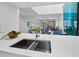 Modern kitchen with quartz countertops and stainless steel sink offering an open view to the living area at 1900 Harbourside Dr # 102, Longboat Key, FL 34228