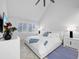 Bright main bedroom featuring a white bed set, tiled floors, natural light from the windows and high vaulted ceilings at 1900 Harbourside Dr # 102, Longboat Key, FL 34228
