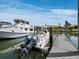 Waterfront view of boats docked alongside the pier, with a charming home visible in the background at 1900 Harbourside Dr # 102, Longboat Key, FL 34228