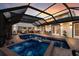 Screened-in pool area with a spa, covered seating, outdoor dining, and lush plants perfect for entertaining at 1932 Baywood Ter, Sarasota, FL 34231