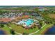 Overhead view of resort style pool, clubhouse, and tennis courts nestled in a tropical community on a lake at 24068 Canterwood Way, Venice, FL 34293
