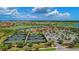 Wide angle aerial shot displaying tennis courts, pool, and clubhouse surrounded by golf course and lakes at 24068 Canterwood Way, Venice, FL 34293