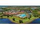 Aerial view of community pool, clubhouse, and tennis courts set amidst lush landscaping and scenic waterfront views at 24068 Canterwood Way, Venice, FL 34293