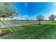 Expansive backyard with lush green grass and a tranquil lake view, ideal for relaxation and outdoor activities at 24068 Canterwood Way, Venice, FL 34293