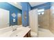 This bathroom includes a single sink vanity, toilet and shower with white curtain, and stylish nautical decor at 24068 Canterwood Way, Venice, FL 34293