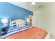 Bright bedroom with blue accent wall, complemented by striped bedding and seaside decor for a calming atmosphere at 24068 Canterwood Way, Venice, FL 34293