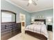 This cozy bedroom features a full dresser, a comfortable bed, and access to the en-suite bathroom at 24068 Canterwood Way, Venice, FL 34293