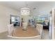 Cozy dining area connected to living room, offering serene views of the lake through large windows at 24068 Canterwood Way, Venice, FL 34293