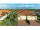 Exterior elevation of home featuring a brick driveway, two-car garage and meticulously landscaped yard at 24068 Canterwood Way, Venice, FL 34293