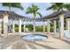 Relaxing hot tub area with shaded pergola, lounge chairs, and privacy landscaping at 24068 Canterwood Way, Venice, FL 34293