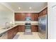 Modern kitchen features stainless steel appliances, granite countertops and dark wood cabinets at 24068 Canterwood Way, Venice, FL 34293