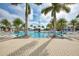 Resort-style pool area framed by lush palm trees and comfortable lounge chairs at 24068 Canterwood Way, Venice, FL 34293