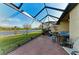 Covered screened lanai featuring brick flooring, comfortable seating and a tranquil view of the lake at 24068 Canterwood Way, Venice, FL 34293