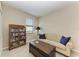 This sitting room features a comfortable couch, wooden trunk coffee table, and full bookcase at 24068 Canterwood Way, Venice, FL 34293