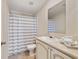 Cozy bathroom featuring a shower-tub combo with striped curtain and neutral-toned vanity at 2502 Larkspur Dr, Punta Gorda, FL 33950