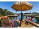 Relaxing waterfront dock featuring a tiki umbrella, chairs, and beautiful canal views at 2502 Larkspur Dr, Punta Gorda, FL 33950