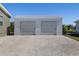 Spacious two-car detached garage with roll up doors and a gravel driveway at 2502 Larkspur Dr, Punta Gorda, FL 33950
