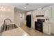 Bright kitchen with stainless steel sink, black appliances, and access to laundry room at 2502 Larkspur Dr, Punta Gorda, FL 33950