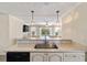 This eat-in kitchen features pendant lighting and views of the living room and pool beyond at 2502 Larkspur Dr, Punta Gorda, FL 33950