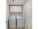 Convenient laundry room equipped with a washer, dryer, and overhead storage cabinets at 2502 Larkspur Dr, Punta Gorda, FL 33950