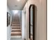 View of the wooden staircase with decorative tile floors and a full-length mirror at 288 Island Cir, Sarasota, FL 34242