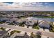 Aerial view of house and neighborhood with manicured lawns, tile roofs, and lake views at 2962 Trustee Ave, Sarasota, FL 34243