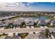 Aerial view of house, paver driveway, lake view, and manicured landscaping in a well maintained community at 2962 Trustee Ave, Sarasota, FL 34243