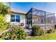 Charming home exterior with a screened lanai, patio furniture, and well-maintained landscaping at 2962 Trustee Ave, Sarasota, FL 34243