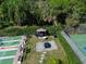 A community area with a shuffleboard court, picnic area and tennis court surrounded by greenery and mature trees at 315 30Th W Ave # B214, Bradenton, FL 34205