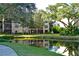 Scenic backyard view with a tranquil pond reflecting the building and lush greenery surrounding the property at 315 30Th W Ave # B214, Bradenton, FL 34205