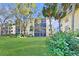 Well-maintained building with a spacious lawn and mature trees in a serene community setting at 315 30Th W Ave # B214, Bradenton, FL 34205