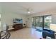 Bright open floor plan with balcony access featuring laminate flooring and ceiling fan at 315 30Th W Ave # B214, Bradenton, FL 34205