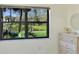 Bedroom with a large window showing a picturesque view of the pond and lush greenery at 315 30Th W Ave # B214, Bradenton, FL 34205