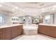 Luxurious bathroom with jacuzzi tub, double vanities, travertine tile, and recessed lighting at 35 Watergate Dr # 1103, Sarasota, FL 34236