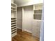 Walk-in closet with custom shelving, drawers, and hanging rods for optimal storage and organization at 35 Watergate Dr # 1103, Sarasota, FL 34236